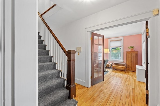 stairs featuring french doors, baseboards, and hardwood / wood-style floors
