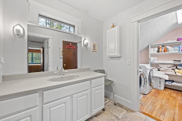 bathroom featuring vanity, plenty of natural light, baseboards, and independent washer and dryer