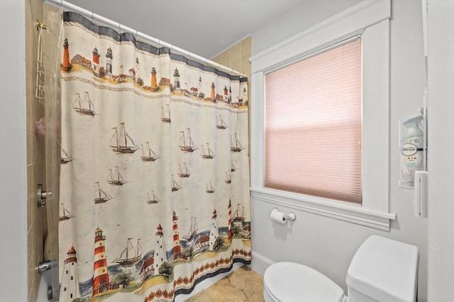 bathroom with a shower with shower curtain and toilet