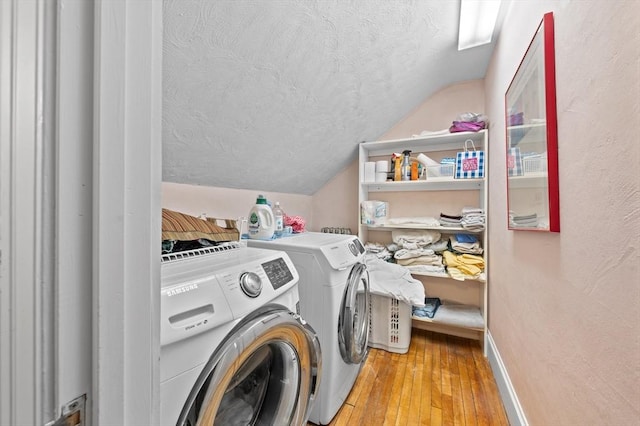 laundry area with washer and dryer, laundry area, a textured ceiling, hardwood / wood-style floors, and baseboards