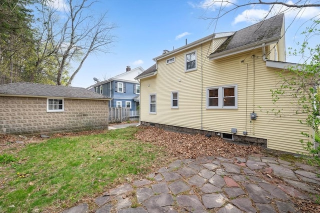 back of house with fence and a yard