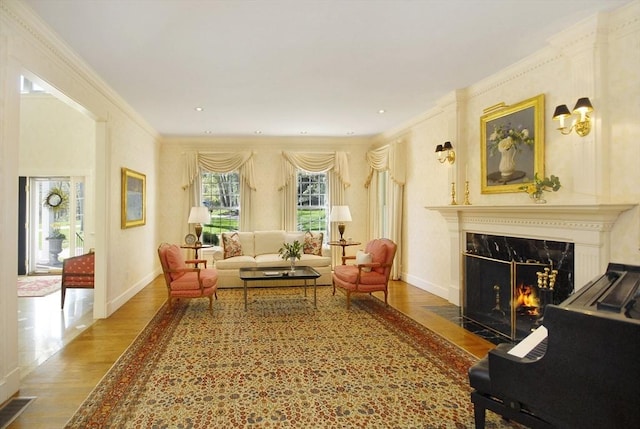 interior space featuring a high end fireplace, wood finished floors, visible vents, crown molding, and baseboards