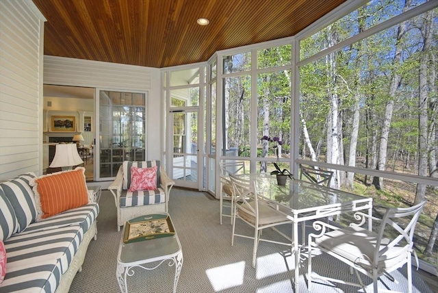 sunroom featuring a healthy amount of sunlight, outdoor dining area, and outdoor lounge area