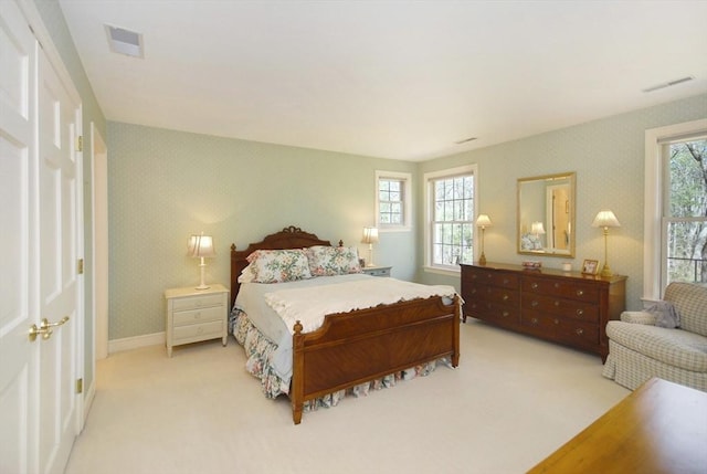 bedroom featuring light carpet, baseboards, visible vents, and wallpapered walls