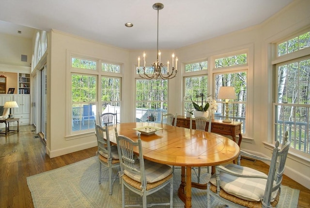 dining area with plenty of natural light, wood finished floors, baseboards, and a notable chandelier