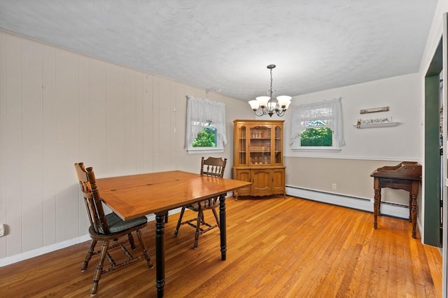 22 Edgewood Ave, West Boylston, MA 01583 - dining room featuring baseboard heating, light wood finished floors, a chandelier, and a textured ceiling