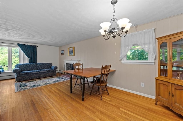 22 Edgewood Ave, West Boylston, MA 01583 - dining space featuring light wood-type flooring, a chandelier, and a baseboard heating unit