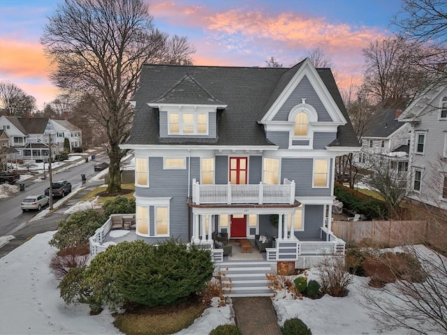 view of front of house with a balcony and covered porch