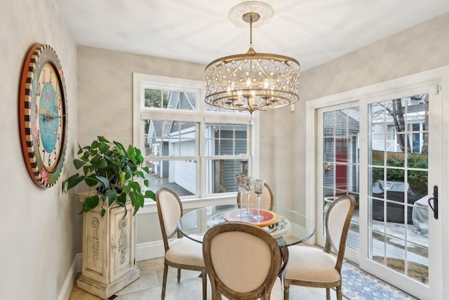 dining space featuring light tile patterned floors, baseboards, and an inviting chandelier