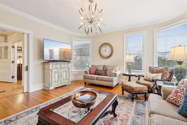 living area with plenty of natural light, wood finished floors, an inviting chandelier, and ornamental molding