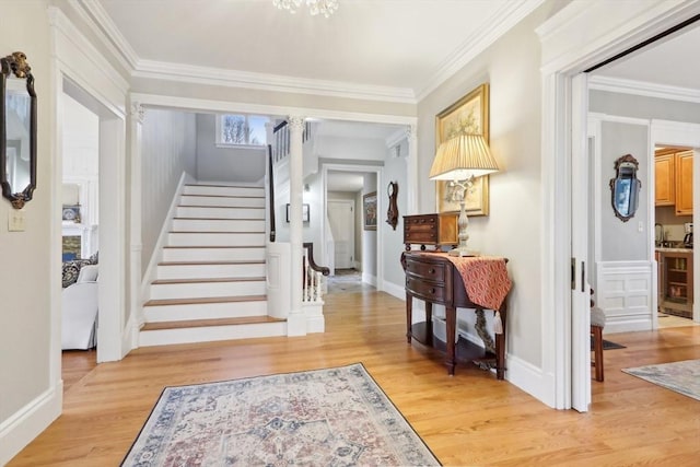 entrance foyer featuring stairway, light wood-style flooring, baseboards, and ornamental molding