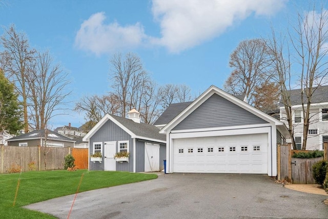 ranch-style home with driveway, fence, an outdoor structure, a front yard, and a chimney