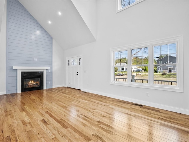 310 Old Westport, Dartmouth, MA 02747 - unfurnished living room with a high ceiling, hardwood / wood-style flooring, baseboards, a glass covered fireplace, and recessed lighting