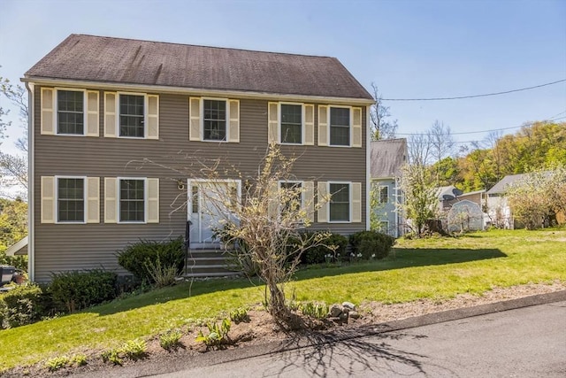 colonial inspired home with a front lawn