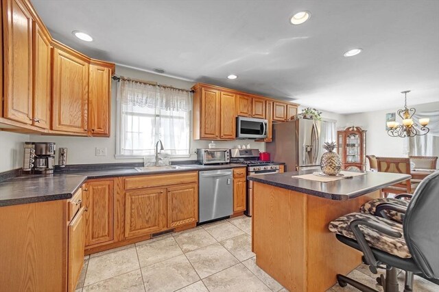 kitchen with a breakfast bar area, dark countertops, a sink, stainless steel appliances, and recessed lighting