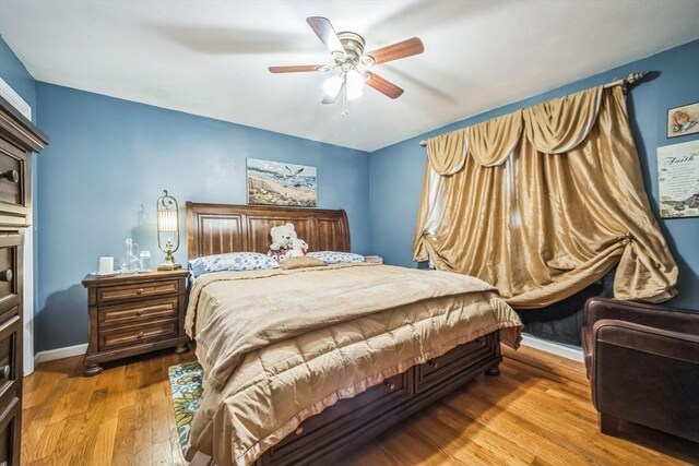 bedroom featuring baseboards, ceiling fan, and wood finished floors