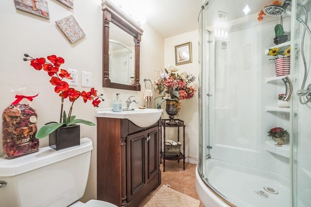 full bath featuring vanity, tile patterned flooring, a stall shower, and toilet