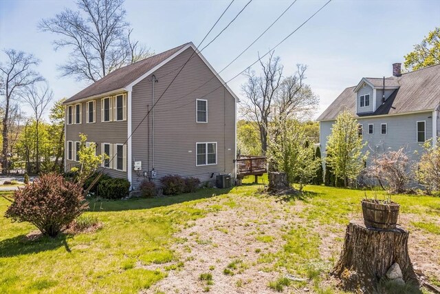 view of side of property with a yard and central AC unit