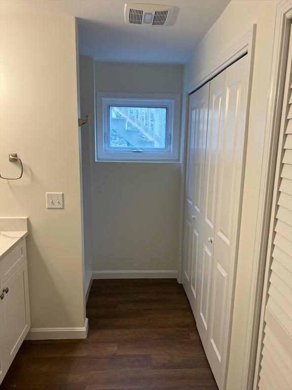 corridor with dark hardwood / wood-style flooring