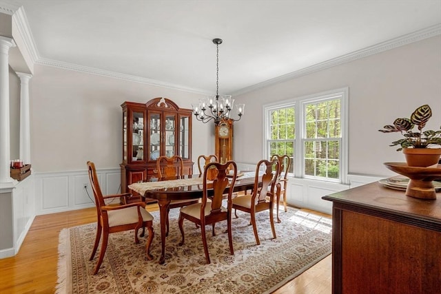 6 Bishop Ln, Middleton, MA 01949 - dining space featuring light wood-type flooring, ornate columns, crown molding, a wainscoted wall, and a chandelier