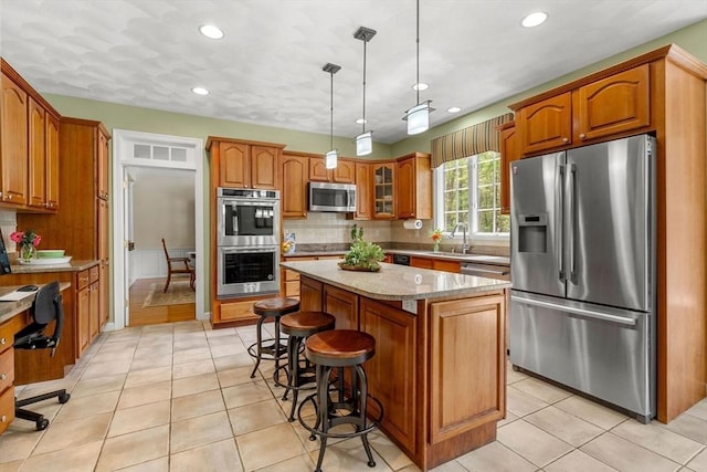 6 Bishop Ln, Middleton, MA 01949 - kitchen with appliances with stainless steel finishes, a sink, brown cabinets, tasteful backsplash, and recessed lighting