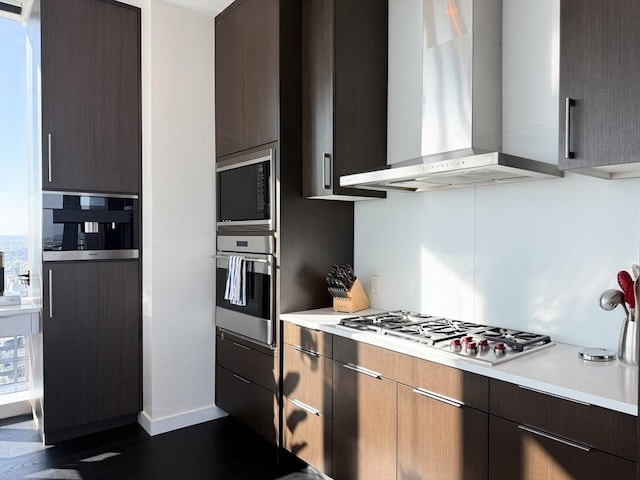 188 Brookline Ave Unit Ph29A, Boston, MA 02215 - kitchen featuring stainless steel appliances, wall chimney range hood, light countertops, baseboards, and modern cabinets