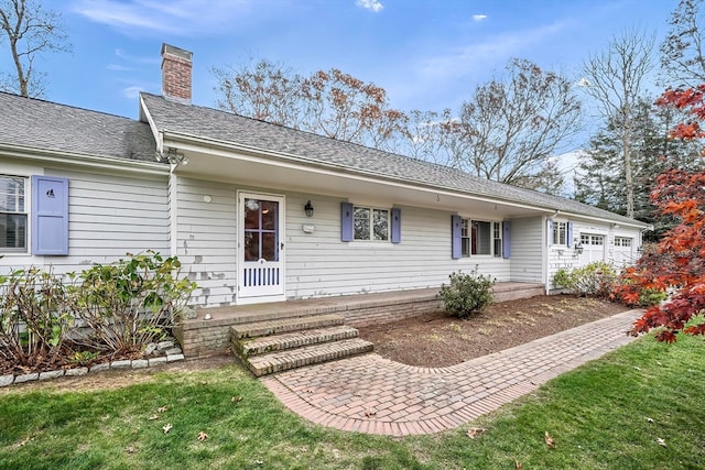 back of property with a yard and a garage