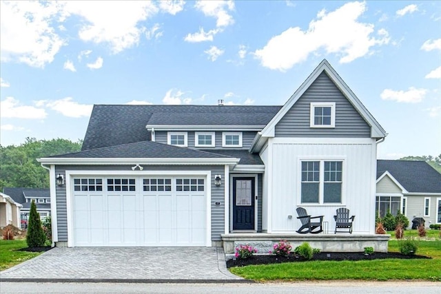 27 Sophia Dr, Rehoboth, MA 02769 - view of front of home featuring covered porch, a garage, decorative driveway, a front yard, and board and batten siding