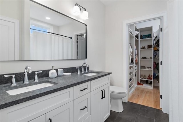 27 Sophia Dr, Rehoboth, MA 02769 - full bathroom featuring double vanity, toilet, a spacious closet, tile patterned floors, and a shower with curtain