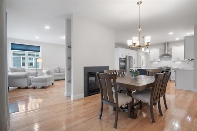 27 Sophia Dr, Rehoboth, MA 02769 - dining space featuring a chandelier, a multi sided fireplace, light wood-type flooring, recessed lighting, and baseboards