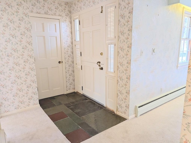 foyer entrance with wallpapered walls, baseboards, stone finish flooring, and baseboard heating