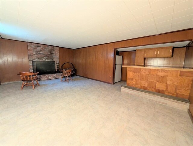 living area featuring a fireplace, wood walls, and light floors