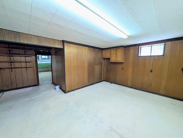 basement featuring wooden walls