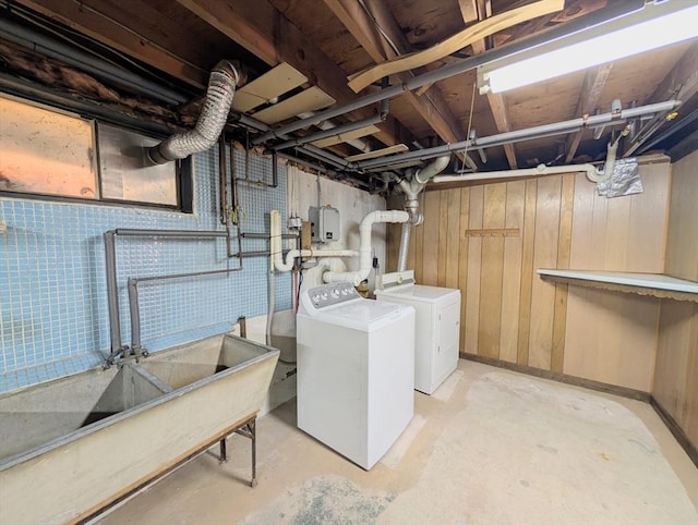 laundry room with washing machine and dryer, wooden walls, and laundry area