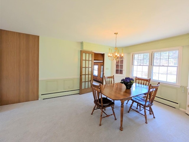dining room featuring baseboard heating, carpet flooring, and a chandelier
