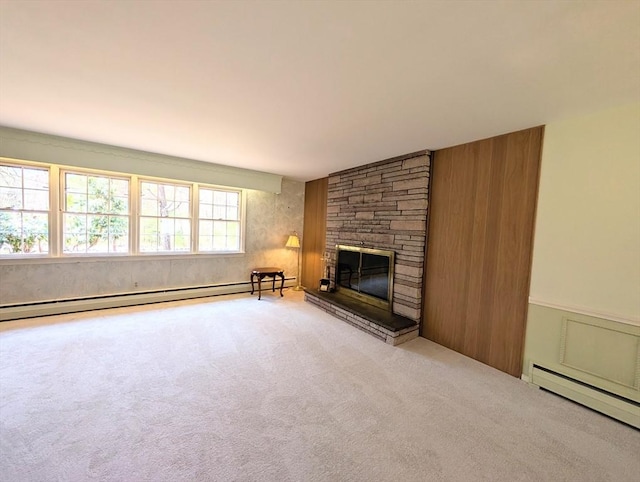 unfurnished living room with baseboard heating, wooden walls, carpet, and a fireplace