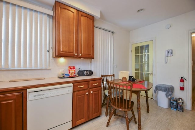 kitchen featuring white dishwasher and backsplash