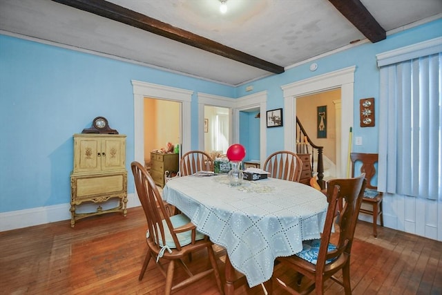 dining area featuring dark hardwood / wood-style floors and beam ceiling