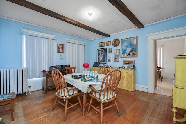 dining area featuring radiator heating unit, dark hardwood / wood-style flooring, and beam ceiling