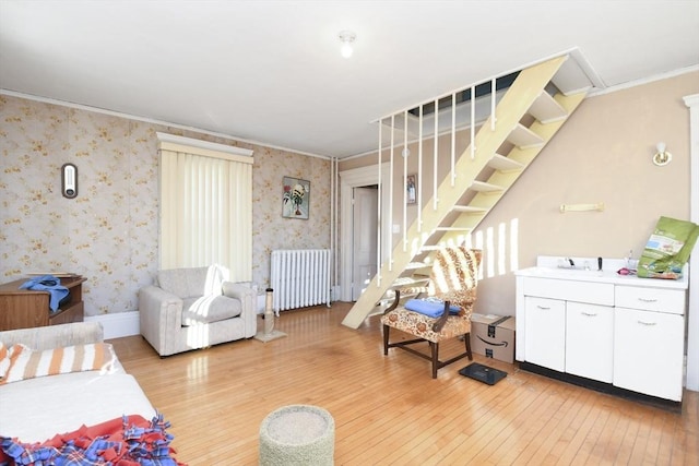 living room featuring ornamental molding, radiator, and light hardwood / wood-style floors