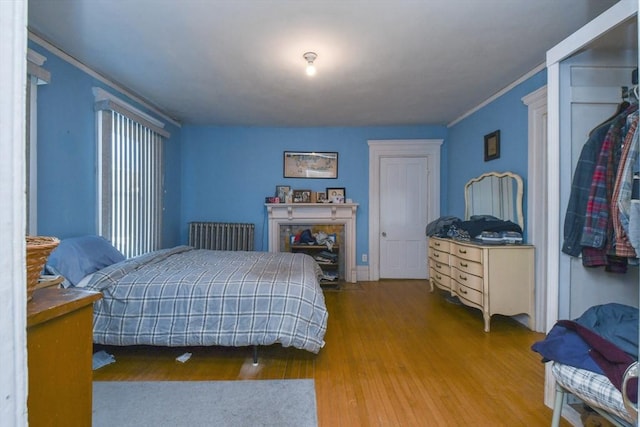 bedroom with ornamental molding and hardwood / wood-style floors