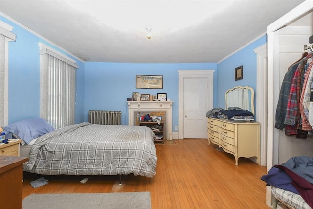 bedroom featuring ornamental molding and light wood-type flooring