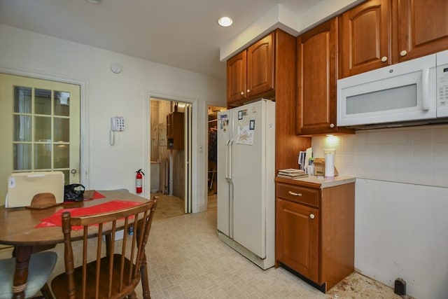 kitchen featuring backsplash and white appliances