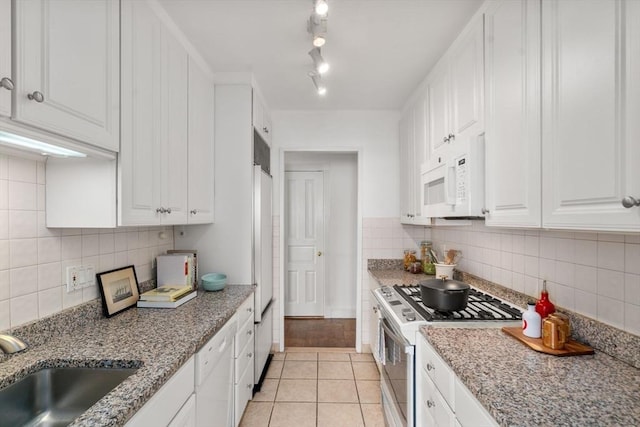 65 E India Unit 27F, Boston, MA 02110 - kitchen featuring white appliances, a sink, light tile patterned floors, and decorative backsplash