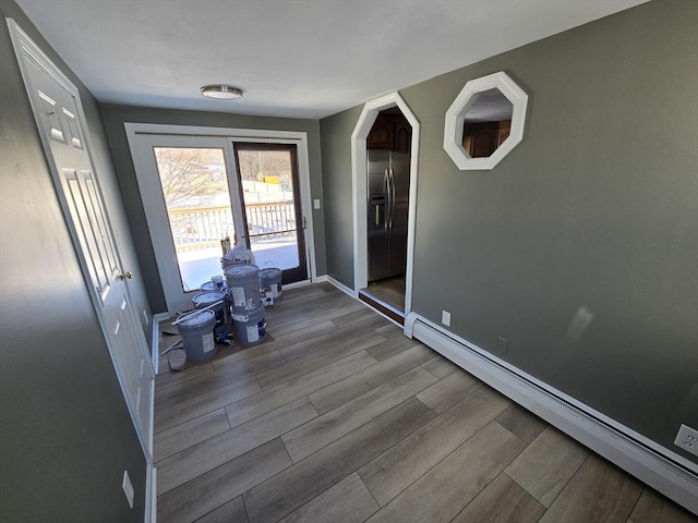 doorway to outside with a baseboard radiator and light hardwood / wood-style floors