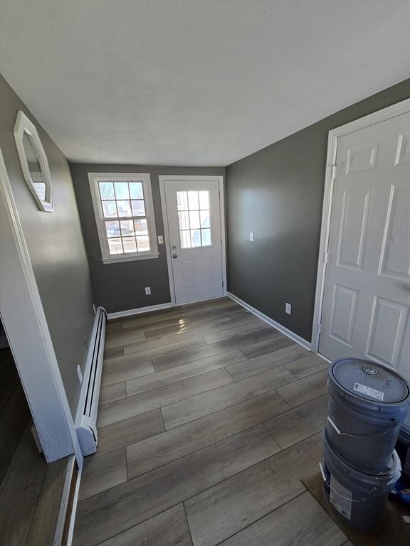 entrance foyer with hardwood / wood-style floors and a baseboard heating unit