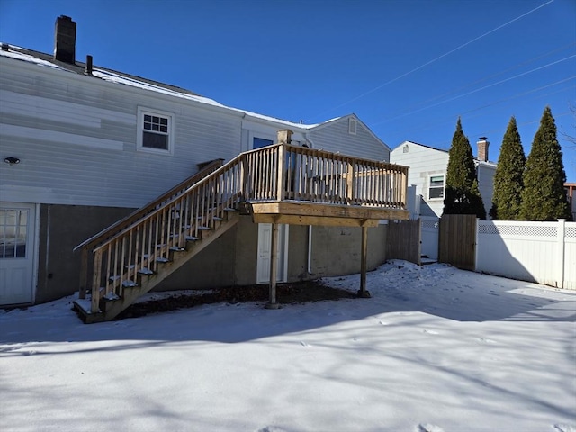 snow covered house with a deck