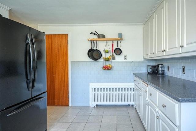 242 Furnace Brook Pkwy, Quincy, MA 02169 - kitchen with freestanding refrigerator, radiator, dark countertops, light tile patterned floors, and white cabinets