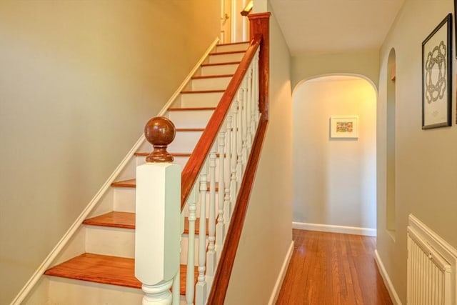 242 Furnace Brook Pkwy, Quincy, MA 02169 - stairway featuring arched walkways, wood-type flooring, and baseboards