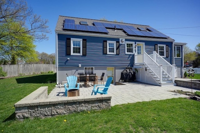 242 Furnace Brook Pkwy, Quincy, MA 02169 - back of property with solar panels, a patio, and roof with shingles